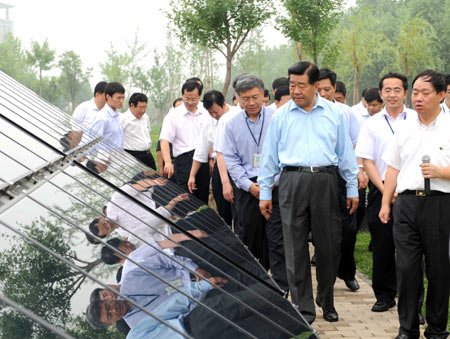 Jia Qinglin (C), chairman of the National Committee of the Chinese People's Political Consultative Conference, visits XinAo Group, a private company specialized in research and development of renewable energy and new energy, during his inspection tour in Langfang, a city in north China's Hebei Province, on July 6, 2009.