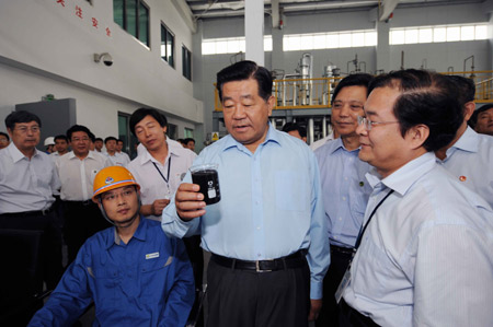 Jia Qinglin (C), chairman of the National Committee of the Chinese People's Political Consultative Conference, visits XinAo Group, a private company specialized in research and development of renewable energy and new energy, during his inspection tour in Langfang, a city in north China's Hebei Province, on July 6, 2009. 