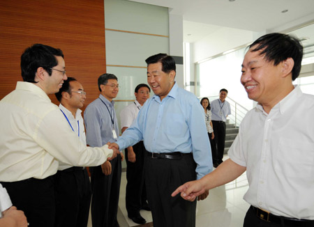 Jia Qinglin (C), chairman of the National Committee of the Chinese People's Political Consultative Conference, visits XinAo Group, a private company specialized in research and development of renewable energy and new energy, during his inspection tour in Langfang, a city in north China's Hebei Province, on July 6, 2009. 