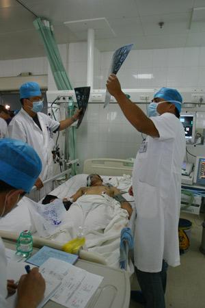 Firemen rescue a man injured in the riot in Urumqi, capital of northwest China's Xinjiang Uygur Autonomous Region, early July 6, 2009. (Xinhua/Li Haitao)