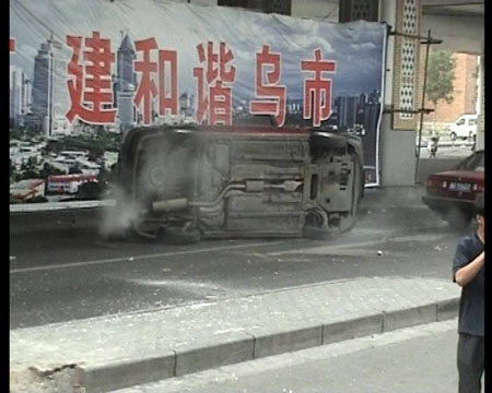 Photo released by police shows a car smashed and overturned by rioters in Urumqi, capital of northwest China's Xinjiang Uygur Autonomous Region on July 5, 2009. [chinadaily.com.cn]