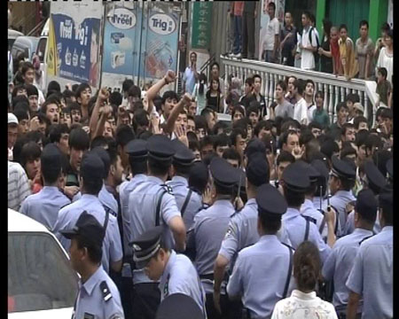 Photo released by police shows police trying to stop chaos and maintain order in Urumqi, capital of northwest China's Xinjiang Uygur Autonomous Region on July 5, 2009. [chinadaily.com.cn]