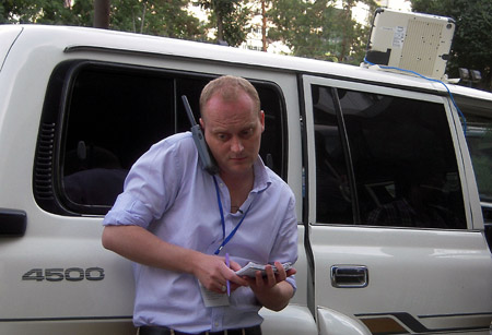 A reporter works outside a news center set up by local government in Urumqi, capital of northwest China's Xinjiang Uygur Autonomous Region, on July 8, 2009. 