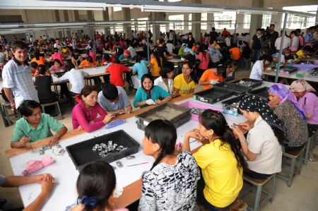 Xinjiang employees work at Xuri toy factory in Shaoguan City, south China's Guangdong Province, on July 7, 2009. More than 700 Xinjiang workers went back to work here on Tuesday after renovation of workshop, dormitory and dining-room. Their work had to be suspended after the fight between Uygur and Han ethnic workers at the toy factory on June 26. 