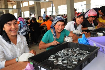 Xinjiang employees work at Xuri toy factory in Shaoguan City, south China's Guangdong Province, on July 7, 2009. More than 700 Xinjiang workers went back to work here on Tuesday after renovation of workshop, dormitory and dining-room. Their work had to be suspended after the fight between Uygur and Han ethnic workers at the toy factory on June 26. 