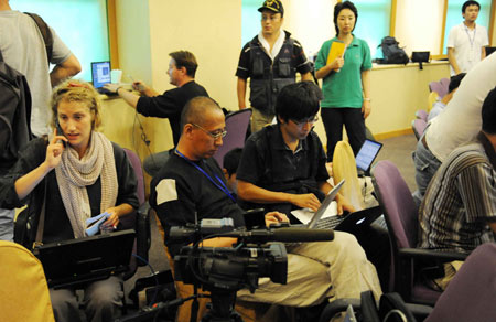 Chinese and foreign journalists work at the press center established at Hoi Tak Hotel in Urumqi, capital of northwest China's Xinjiang Uygur Autonomous Region, on July 7, 2009. More than 60 overseas media have sent journalists to Urumqi after a riot broke out in the city Sunday, leaving 156 people dead and 1,080 others injured. 