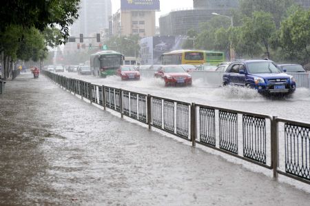 Vehicles struggle on the flooded road in Nanjing, capital of east China's Jiangsu Province, on July 7, 2009. A heavy downpour drenched the city and blocked the traffic from Monday night to Tuesday morning.