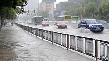 Vehicles struggle on the flooded road in Nanjing, capital of east China's Jiangsu Province, on July 7, 2009. A heavy downpour drenched the city and blocked the traffic from Monday night to Tuesday morning.