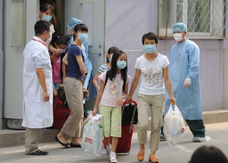 People leave after being quarantined due to influenza A/H1N1 concern for a week in Beijing, capital of China, on July 7, 2009.