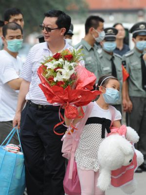 People leave after being quarantined due to influenza A/H1N1 concern for a week in Beijing, capital of China, on July 7, 2009. 