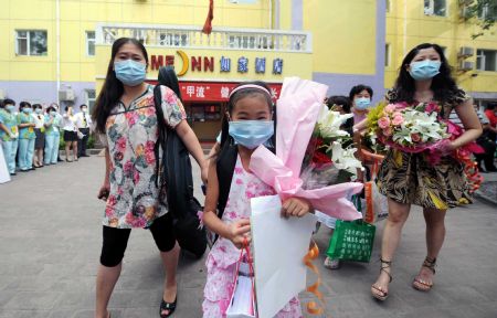 People leave after being quarantined due to influenza A/H1N1 concern for a week in Beijing, capital of China, on July 7, 2009.