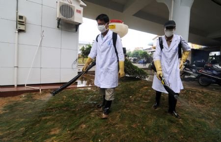 Two epidemic prevention workers sterilize the city after the flood receded in Liuzhou City of southwest China's Guangxi Zhuang Autonomous Region, on July 7, 2009. The flood passing through Liujiang River receded on July 6 and local people began to clean the city and restore the basic facilities.