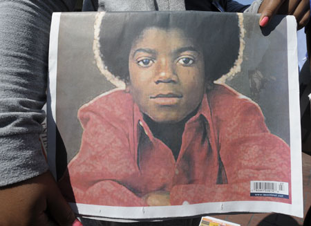 A fan holds a picture of Michael Jackson outside the Staples Center in Los Angeles on July 7, 2009. A star-studded public tribute to Michael Jackson was held here Tuesday with thousands of randomly selected fans joining family and friends to bid farewell to the King of Pop.