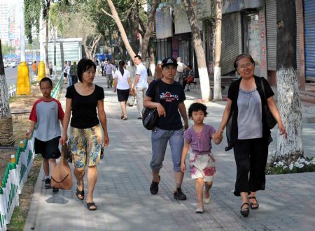 Parents take their children to a park in Urumqi, capital of northwest China's Xinjiang Uygur Autonomous Region, on July 8, 2009.