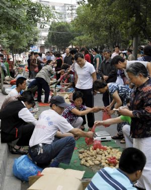 People buy vegetables at a market in Urumqi, capital of northwest China's Xinjiang Uygur Autonomous Region, on July 8, 2009.