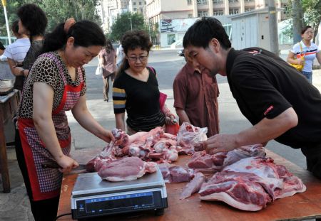 People buy meat at a market in Urumqi, capital of northwest China's Xinjiang Uygur Autonomous Region, on July 8, 2009. 