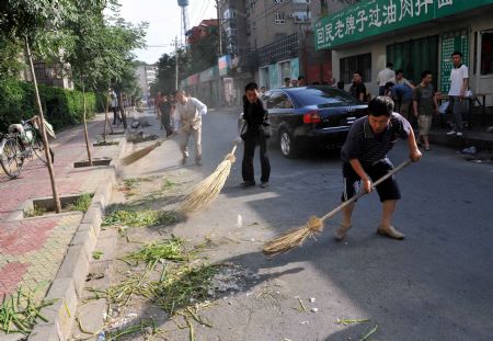 People clean a road in Urumqi, capital of northwest China's Xinjiang Uygur Autonomous Region, on July 8, 2009.