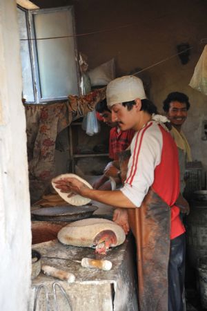 People work at a small restaurant in Urumqi, capital of northwest China's Xinjiang Uygur Autonomous Region, on July 8, 2009.