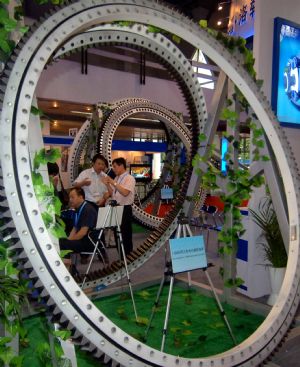 Visitors talk about an equipment on display during the 6th Asian Wind Energy Exhibition in Beijing, capital of China, on July 8, 2009. The exhibition, attended by 445 enterprises from 22 countries and regions, kicked off here Wednesday.