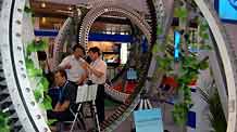 Visitors talk about an equipment on display during the 6th Asian Wind Energy Exhibition in Beijing, capital of China, on July 8, 2009. The exhibition, attended by 445 enterprises from 22 countries and regions, kicked off here Wednesday.