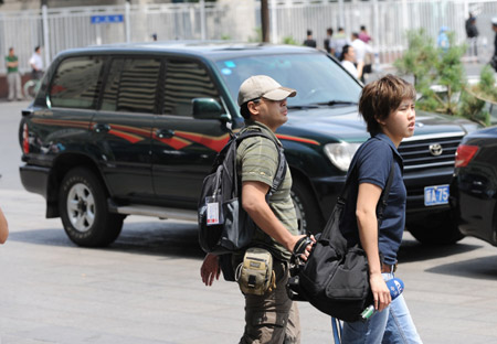 Journalists from southeast China's Taiwan walk on a street in Urumqi, capital of northwest China's Xinjiang Uygur Autonomous Region, on July 8, 2009.