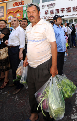 A resident buys vegetables at the Erdaoqiao market in Urumqi, capital of northwest China's Xinjiang Uygur Autonomous Region on July 9, 2009. 