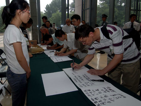 People write down their mourning messages when mourning for renowned Chinese scholar Ji Xianlin in a mourning hall set up at Peking University in Beijing on July 12, 2009.