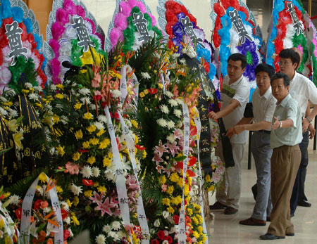 People bring wreaths to mourn for renowned Chinese scholar Ji Xianlin in a mourning hall set up at Peking University in Beijing on July 12, 2009.