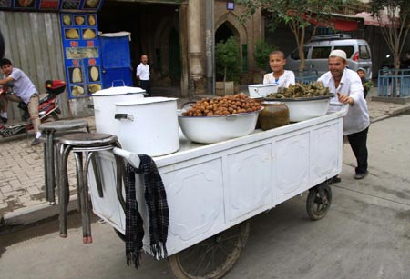 A vendor pulls a food cart in Kashgar city, northwest China's Xinjiang Uygur Autonomous Region, on July 12, 2009. Businesses have recovered and prices have fallen to normal level in the city.