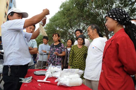 A vendor (L) shows how to make noodle in Kashgar city, northwest China's Xinjiang Uygur Autonomous Region, on July 12, 2009. Businesses have recovered and prices have fallen to normal level in the city.