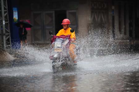 A motorcyclist wades through an inundated street after strong rainfalls brought upon by tropical storm Soudelor in Qionghai City, south China's Hainan Province, on July 12, 2009. 