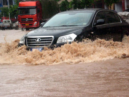 A car wades through the inundated street of the Daxian County in Dazhou City, southwest China&apos;s Sichuan Province, on July 11, 2009. Strong rainfalls hit large area of Dazhou after the noon on Sunday. A total of 10,2000 residents were transfered to safe place and 2 persons were reported missing during the disaster.