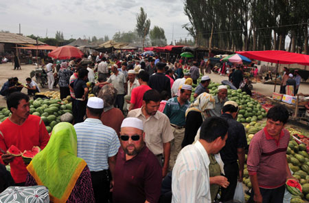 Photo taken on July 12, 2009 shows a bustling bazaar in Aksu, northwest China's Xinjiang Uygur Autonomous Region. Local residents of various ethnic groups went to bazaars, their traditional markets, for shopping on Sunday. 