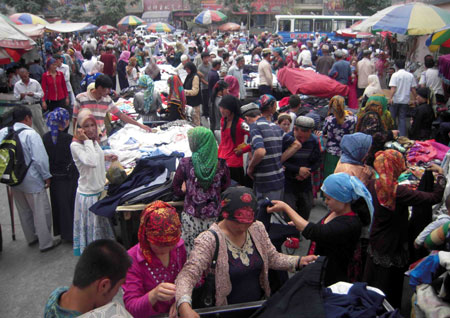 Photo taken on July 12, 2009 shows a bustling bazaar in Hotan, northwest China's Xinjiang Uygur Autonomous Region. Local residents of various ethnic groups went to bazaars, their traditional markets, for shopping on Sunday.