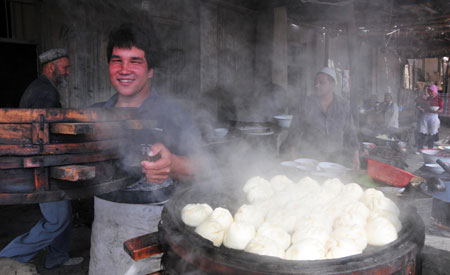 A vendor sells steamed stuffed bun at the largest bazaar in Aksu, northwest China's Xinjiang Uygur Autonomous Region, on July 12, 2009. Local residents of various ethnic groups went to bazaars, their traditional markets, for shopping on Sunday. 