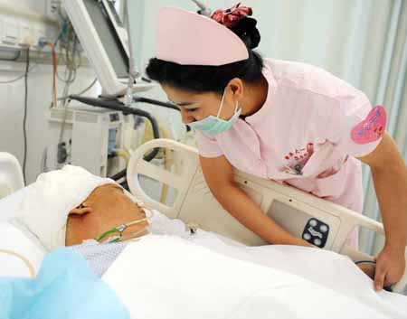 A Uygur nurse watches over an injured person at the No.1 Hospital affiliated to Xinjiang Medical University in Urumqi, capital of China's Xinjiang Uygur Autonomous Region, on July 13, 2009. Xinjiang is slowly returning to normal after a deadly riot broke out in capital city Urumqi on July 5, 2009.