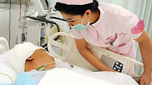 A Uygur nurse watches over an injured person at the No.1 Hospital affiliated to Xinjiang Medical University in Urumqi, capital of China's Xinjiang Uygur Autonomous Region, on July 13, 2009. Xinjiang is slowly returning to normal after a deadly riot broke out in capital city Urumqi on July 5, 2009.