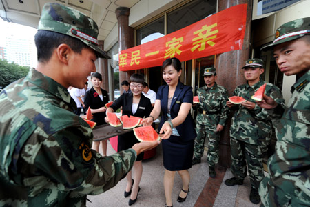 Employees of Rongdu Hotel send watermelons to policemen who are on duty in Urumqi, capital of northwest China's Xinjiang Uygur Autonomous Region, on July 13, 2009.