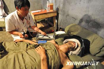 In this photo released by the Xinhua news agency, miner Wang Kuangwei receives medical treatments after being lifted out of the flooded Xinqiao Coal Mine in Qinglong County in southwest China's Guizhou Province, on Sunday July 12, 2009. Wang and two other miners, who had been trapped in the flooded Xinqiao Coal Mine in Guizhou Province for 25 days, were rescued Sunday, Xinhua said. AP 