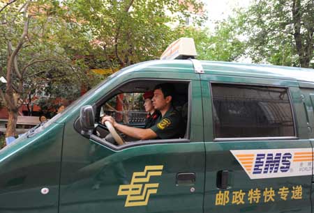 Two employees of the Urumqi Post Bureau drive to deliver a college admission letter in Urumqi, capital of northwest China&apos;s Xinjiang Uygur Autonomous Region, on July 14, 2009.