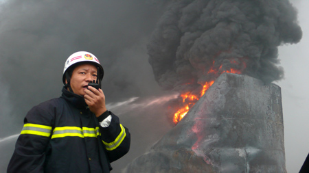 A commander directs firefighters to put out fire at the Luoran chemical plant in Guxian Township of Yanshi City, central China's Henan Province, on July 15, 2009. A blast occurred at the Luoran chemical plant on early Wednesday morning, which was followed by a fire. The blast caused at least four people dead and more than 100 others injured. The investigation of the accident was underway.