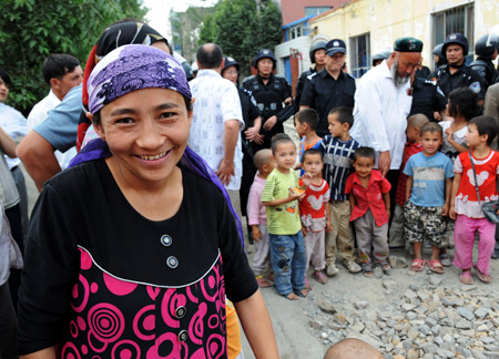 A Uygur woman smiles to the camera on Pingding Hill in Urumqi, capital of northwest China's Xinjiang Uygur Autonomous Region, July 14, 2009. The residents of various ethnic groups living on Pingding hill resumed their peaceful and harmonious life after the deadly July 5 riot, thanks to the peacekeeping police force who managed to maintain ethnic unity and social stability here by helping locals recognize the truth and publicising the ethnic policy with their sincerity.