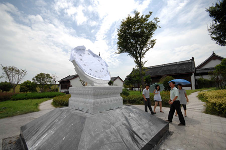 People watch the newly-installed equatorial sundial, measuring 1.5 meters in diameters, donated by the National Observatory to mark the spot for observation of the forthcoming 2009 total solar eclipse on the Yangtze Valley, believed to be the longest one visible in the century that is to betide on July 22, in Haining, east China's Zhejiang Province, on July 15, 2009.