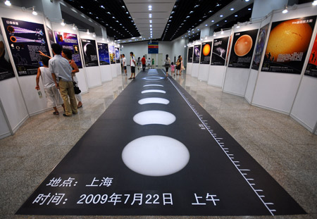 Local citizens watch the sketch maps illustrating the whole process of the full solar eclipse, during a popular science exhibition on the introduction to the forthcoming 2009 Full Solar Eclipse at the Shanghai Science and Technology Museum, in Shanghai, east China, on July 11, 2009. The upcoming full solar eclipse, predicted to betide on July 22 and believed to be the longest of its kind in 500 years, will be visible in most parts of the Shanghai municipality.