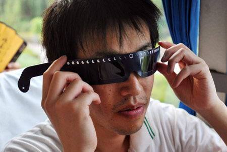 A resident of Japanese city of Oita shows his solar eclipse observing spectacle as he arrives in Wuhan City, central China's Hubei Province, on July 18, 2009. The delegation, consisting of some 160 Oita citizens, arrived in Wuhan for their planned observation of the longest total solar eclipse of the 21st century, set to occur on July 22 over China. 