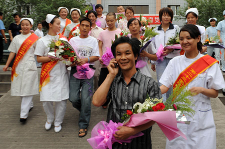 Yan Cailu, who was wounded in the July 5 riot, calls his relatives as he leaves the hospital in Urumqi, capital of northwest China's Xinjiang Uygur Autonomous Region, on July 15, 2009.