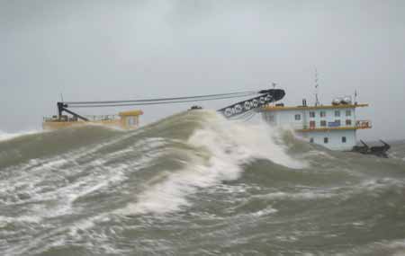 A vessel rescues an engineering barge in danger on the sea off Shantou in south China's Guangdong Province, July 19, 2009. The engineering barge with its seven crew members was successfully rescued on July 19, after it was wrapped on the sea due to typhoon Molave on July 18.