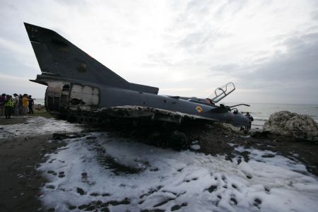 Investigators inspect the Kfir fighter plane crash site at an airport in Cartagena, Colombia, on July 20, 2009. Two pilots aboard the plane survived the accident on Monday. 