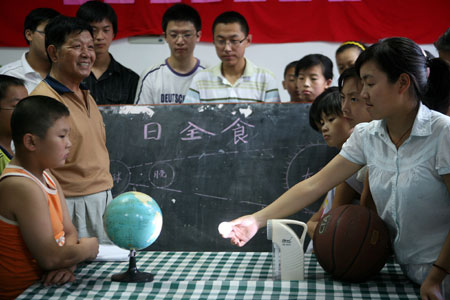 A group of Chinese kids learn the theory of total solar eclipse one day prior to the total solar eclipse observation at Taizhou City in east China's Jiangsu Province, on July 21, 2009.