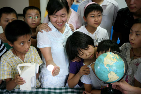 A group of Chinese kids learn the theory of total solar eclipse one day prior to the total solar eclipse observation at Taizhou City in east China's Jiangsu Province, on July 21, 2009.